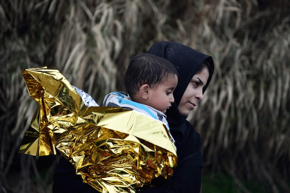 «Μητέρα πρόσφυγας από Συρία κρατά τον γιο της, μετά την αποβίβαση τους στην Λέσβο. Νοέμβρης 2015»