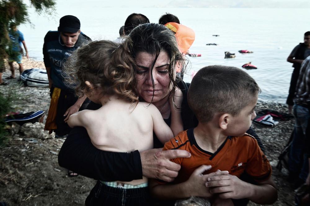 «Μητέρα από Συρία κρατάει τα παιδιά της κατά την αποβίβαση από φουσκωτό στην Κω. Αύγουστος 2015»
