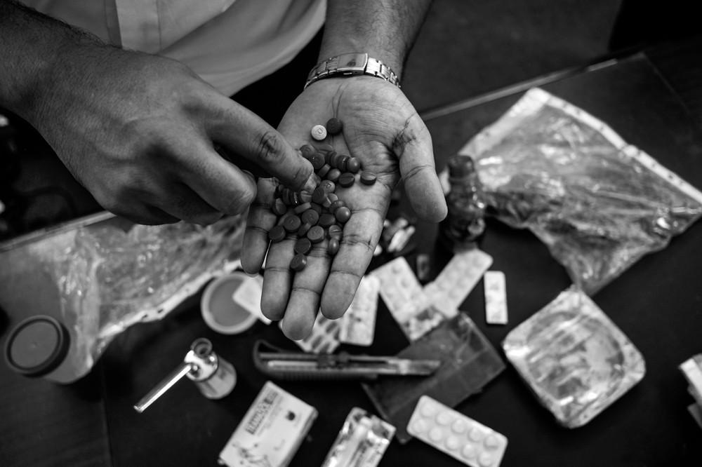 A cop from Palestine&#039;s anti-drug task force shows pills seized during a recent bust