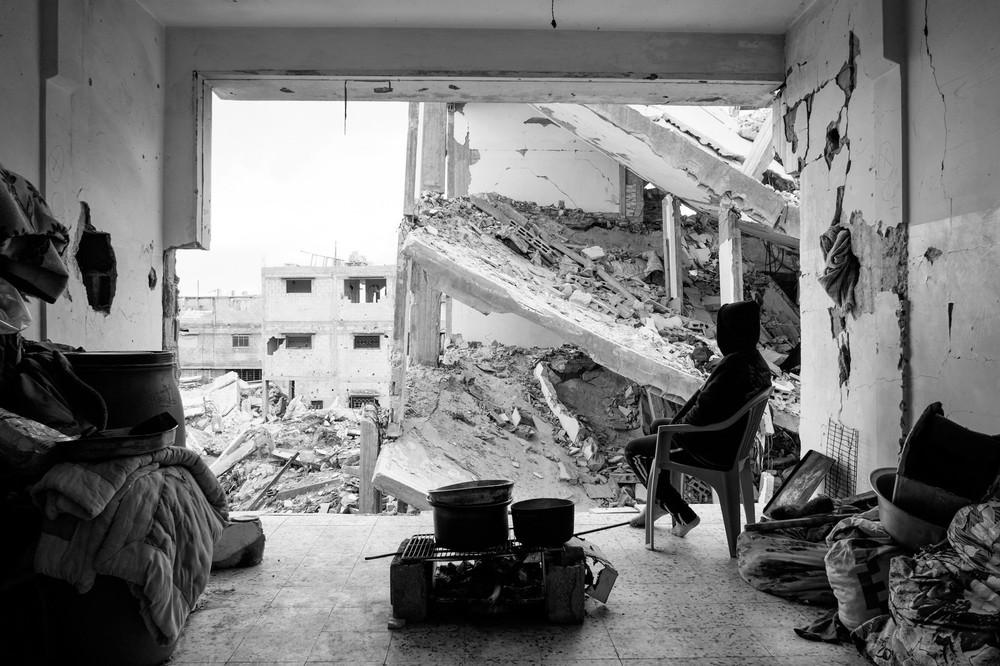 A boy sitting in the living room of his destroyed home in Shejaiya