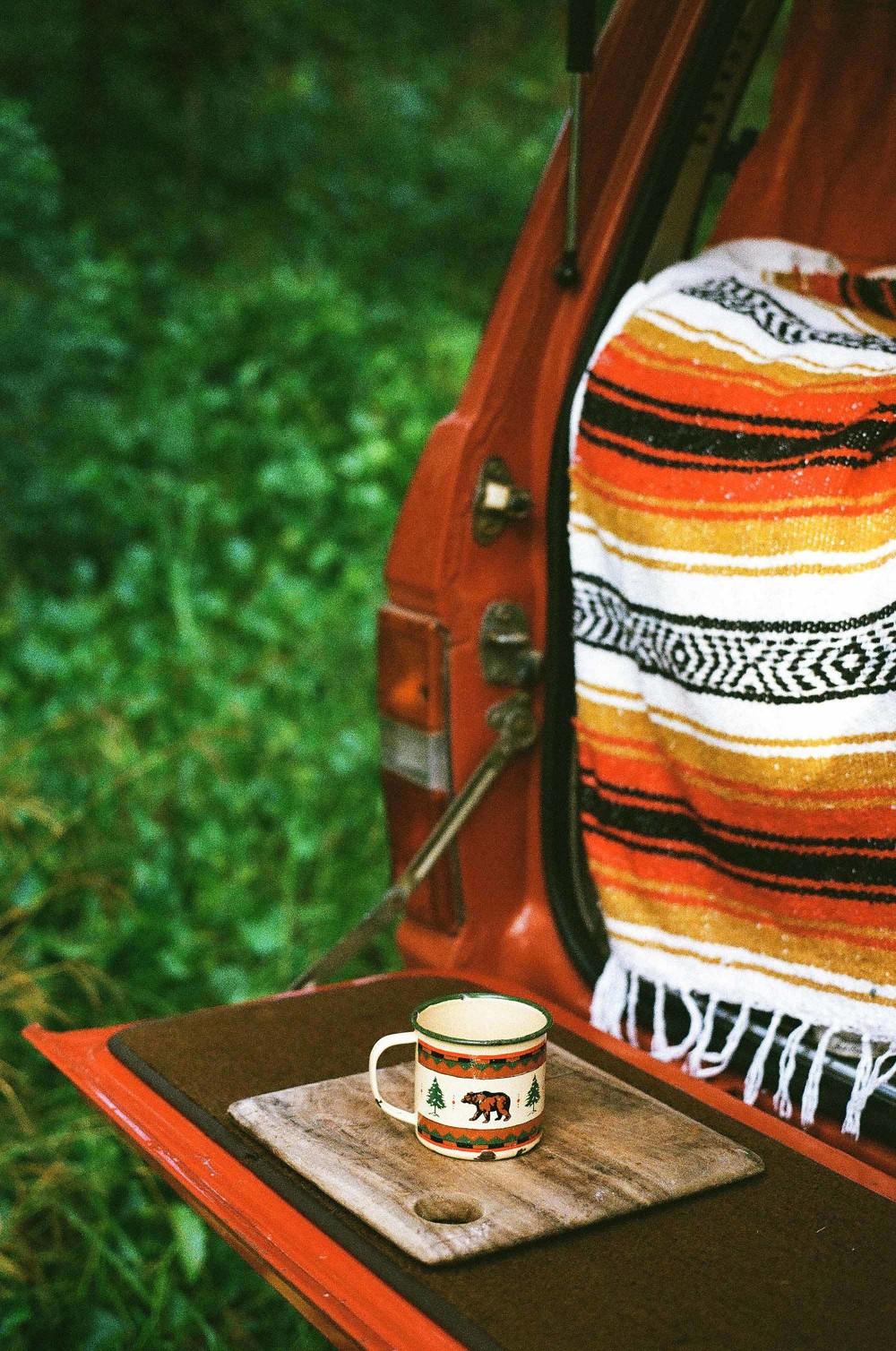 A cup of instant coffee brewed on the tailgate of a classic 60 series Land Cruiser to get the day started