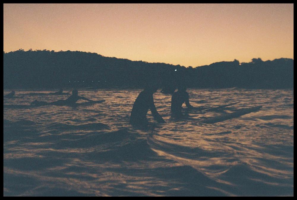 I shot this during a quiet moment one evening, swimming with my camera looking back on some great friends getting their last few waves at dusk