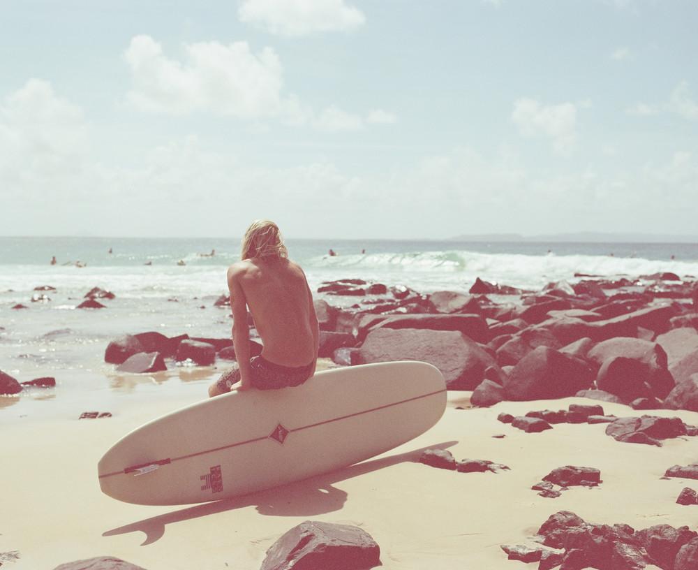 Kai Ellis Flint taking a moment of relaxation on his board, watching some world class surfers catch some fun waves at Tea Tree, Noosa