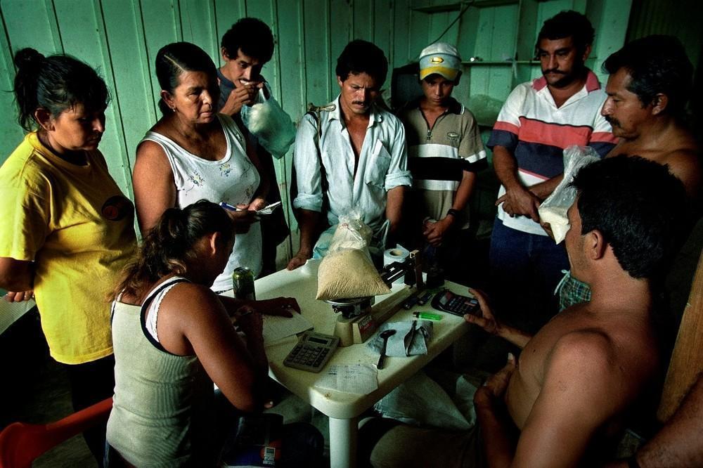 Ένας έμπορος ναρκωτικών αγοράζει σακιά κόκας από αγρότες. Κολομβία, 2002. 